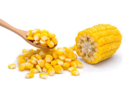 Delicious sweet yellow ripe corn kernels are placed in a wooden spoon and placed on the ground. White backgroundの写真素材