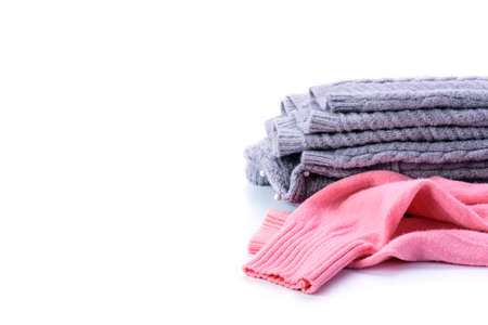 pink and gray sweater folded over a white background.