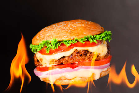 delicious hamburger burger with flame on a dark backgroundの写真素材