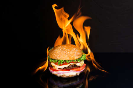 delicious hamburger burger with flame on a dark backgroundの写真素材