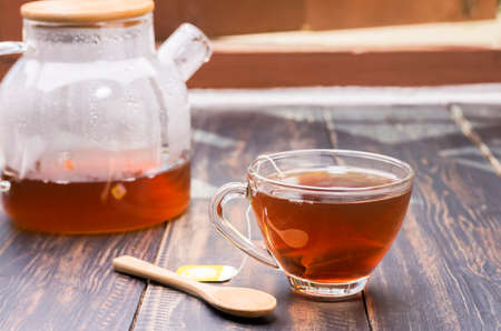 Close-up shot of a cup of hot tea or coffee placed on a desk or a table, drinking coffee by the...