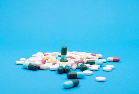 green capsule pill on blue background table medicine vitamin antibiotic and medical treatment of hospital and clinicの写真素材