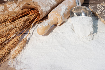 Flour and ears of wheat, barley, cooking, bread, and cookies were arranged on the wooden table background in a rustic kitchen. Top view.の写真素材