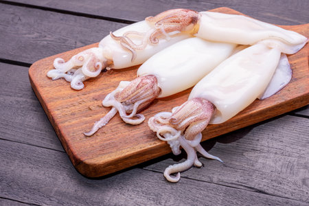 Fresh squid or raw squid on a wooden board Seafood menu on wooden background. Top view.の写真素材