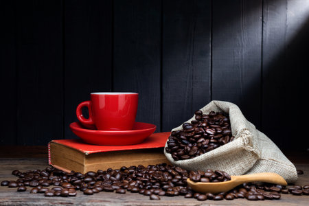 Black coffee or hot tea in a cappuccino espresso cup, breakfast food with coffee beans on a wooden table Isolated on a dark backgroundの写真素材