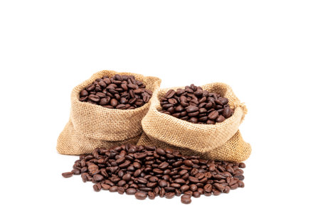 Heap of brown roasted coffee beans in burlap bags isolated on white background. fresh coffee beans conceptの写真素材