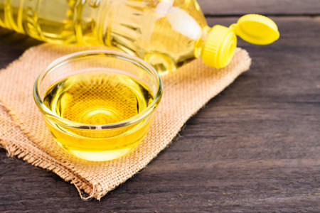 Vegetable oil in a cup With a bottle of vegetable oil placed on an old wooden tableの写真素材