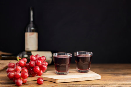A bunch of red grapes with red grape juice in a glass placed on a wooden table or red wine, delicious natural healthy juice drink.の写真素材