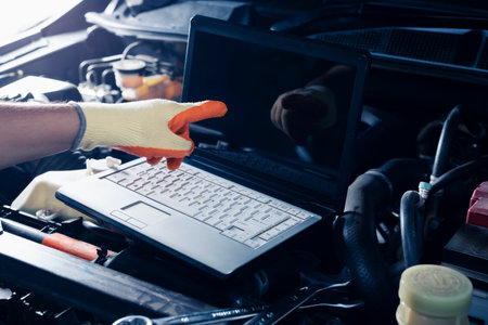 Car inspection service using a modern computer system.  and a modern mechanic in the garage Auto mechanics use computer software to check two engines are running and repair them.の写真素材