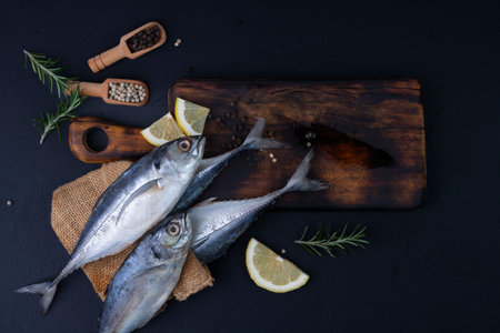 Raw mackerel, seafood, ready to cook on black backgroundの写真素材