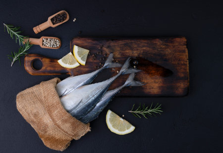 Raw mackerel, seafood, ready to cook on black backgroundの写真素材