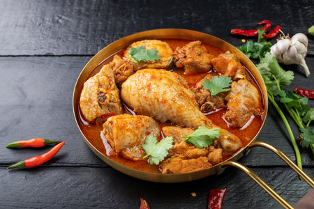 Herbal Chicken Leg Curry or Healthy Cooked Food Stew Arranged on Black Wooden Table, Top View
