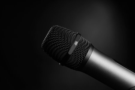 Close-up black and white shot of a microphone in a studio or concert on stage, on a black background.の写真素材