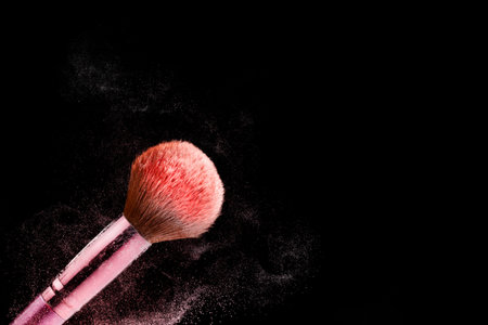 Pink color makeup tools for women's fashion and beauty on face isolated on black background