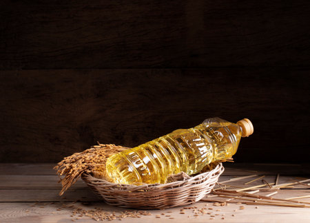 Vegetable oil extracted from rice grains is packed in glass or plastic bottles with golden yellow rice grains, an agricultural product.の写真素材