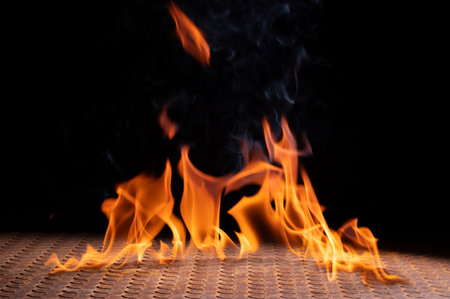 Bonfire flames burning on iron floor isolated on black backgroundの写真素材