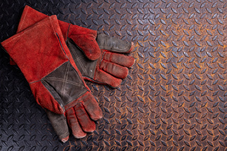 Red work gloves, repairman, welder, laying on rusty metal surface, top viewの写真素材