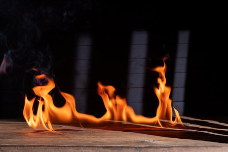Bonfire flames burning on the floor or wooden table on black background.の写真素材