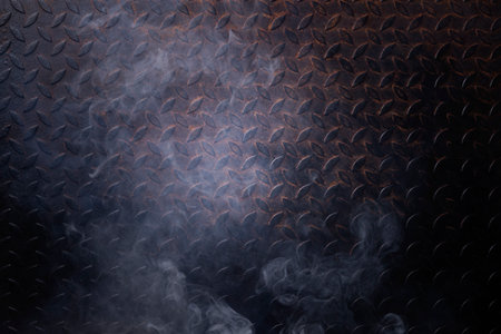The iron floor in the dark has light and has a black background smoke.の写真素材