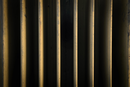 pattern of yellow line between deep shadow grove, low key tone, steel fins of electrical generator