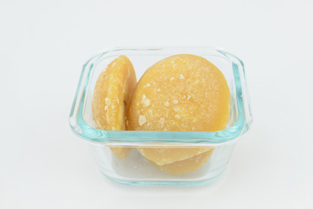 lump of palm, coconut sugar Jakkery in glass container, isolate backgroundの写真素材
