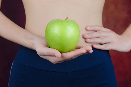 slim asian woman  carries green apple in handの写真素材