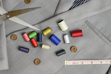 cutting, tailored equipments on double breasted suit, measurement tape, scissors, thread coil