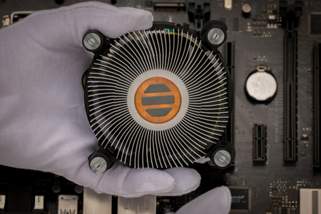 New CPU heat sink with handle and background motherboard background.