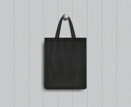 Black tote on wood wall. Mockup of eco canvas bag with handle. Cotton fabric tote. Reusable cloth of ecobag for shopping, grocery, market, beach. Realistic fashion handbag. Template of design. Vector.のイラスト素材