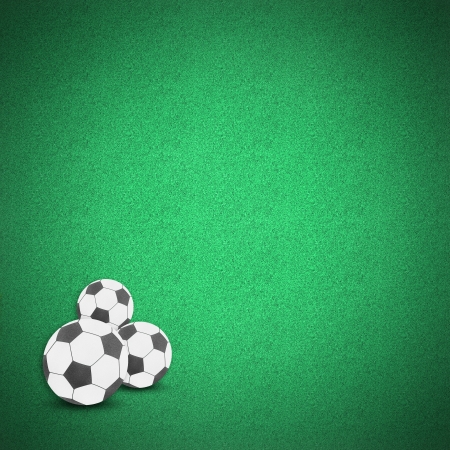 Football soccer ball craft on green grass background by cork boardの写真素材