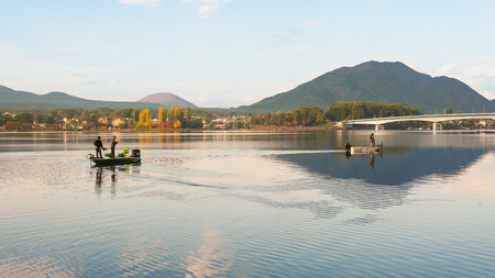 Fuji and lake kawaguchiko with fisherman on the boatの写真素材