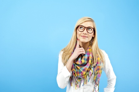 young woman look up on blue backgroundの写真素材