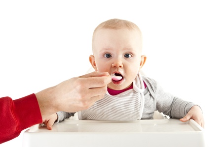 baby in seat and eatingの写真素材