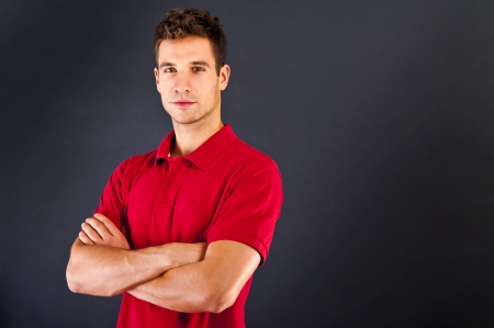 Man on black background in red shirt with smileの写真素材
