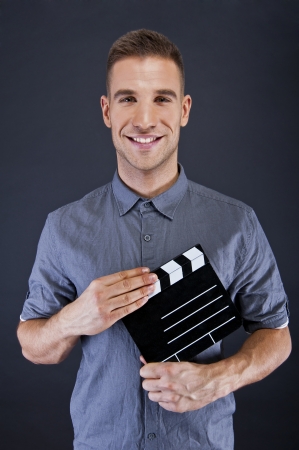 Man with movie clap over dark backgroundの写真素材