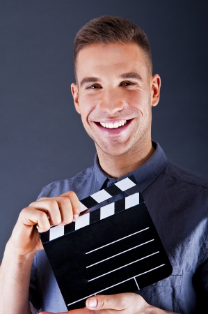 Man with movie clap over dark backgroundの写真素材