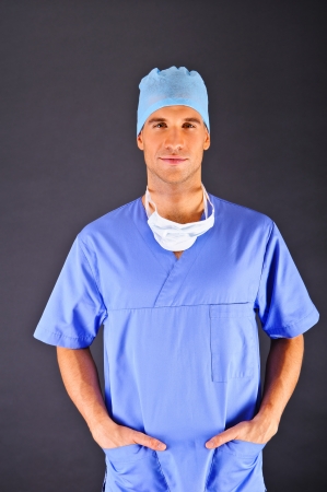 Doctor over dark background in blue shirtの写真素材