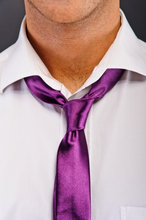 Man with purple tie over dark backgroundの写真素材