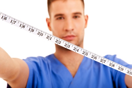 Surgeon with centimeter over white background の写真素材