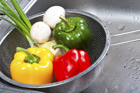 sweet peppers in kitchen sinkの写真素材