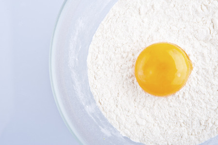 Broken egg on flour, means for making breadの写真素材
