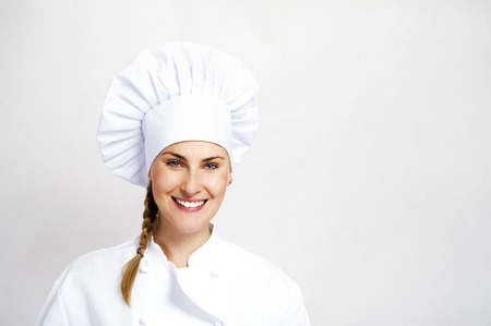 A young, female chef in a traditional hat and coat.の写真素材