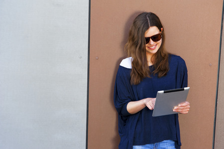 Young woman using a digital tablet computer with big smileの写真素材
