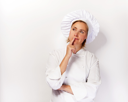 Woman chef look up and thinking with finger near her face, over white background.の写真素材
