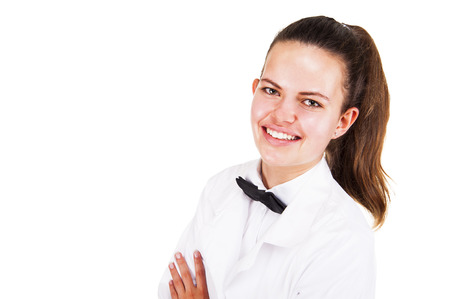 Scince woman in lab coat and bow tai smiling over white background.