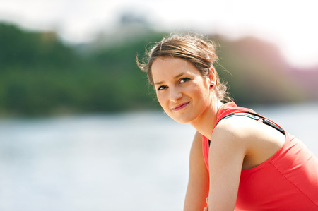 Fit woman resting after run by the river.の写真素材