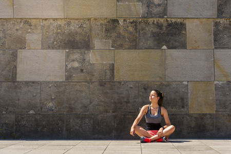 Young athletic woman resting after exercising in the city outdoors.の写真素材