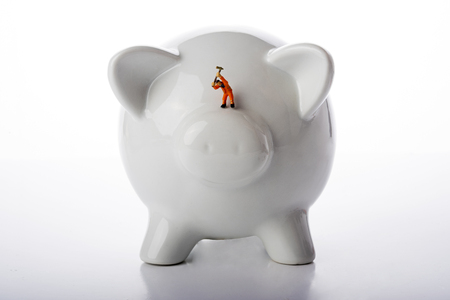 Miniature people workers over pigy bank on white backgroundの写真素材