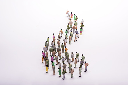 Line of miniature people view from above, over white background.の写真素材