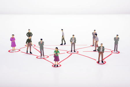 Miniature business people in conection scheme over white backdrop or background.の写真素材
